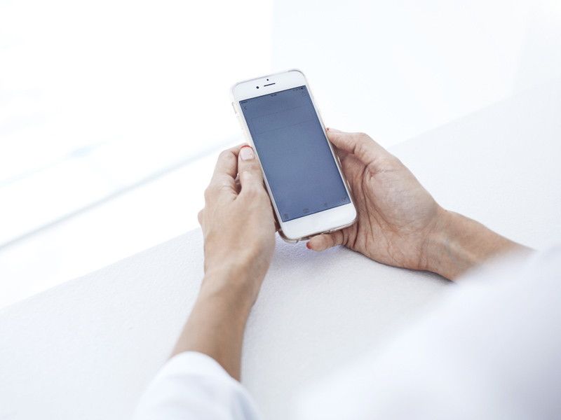 a photo showing a person holding a phone up and looking at their message received through a marketing campaign